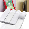 White adhesive picture hanging strips are shown in various forms and angles against a light background.