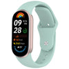 A light mint green silicone replacement strap for a fitness tracker, showing a digital display with date and activity metrics
