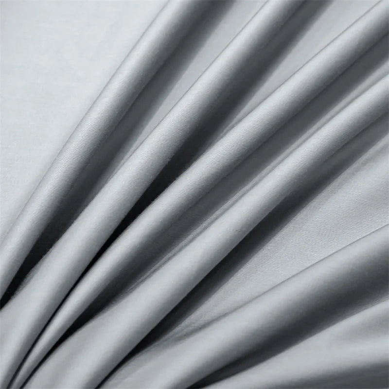 A close-up of a light gray luxury bamboo flat sheet draped softly, showing its silky texture and folds.