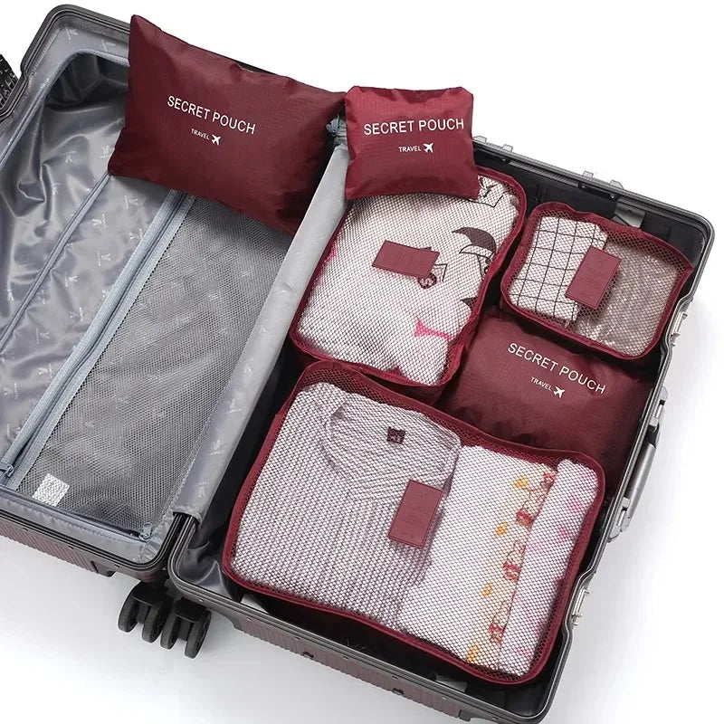 A dark gray travel packing cube case containing six maroon and white laundry pouches.