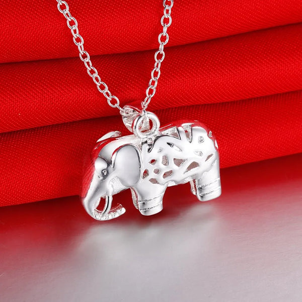 Pendentif en argent sterling en forme d'éléphant, présenté sur un fond de tissu rouge.