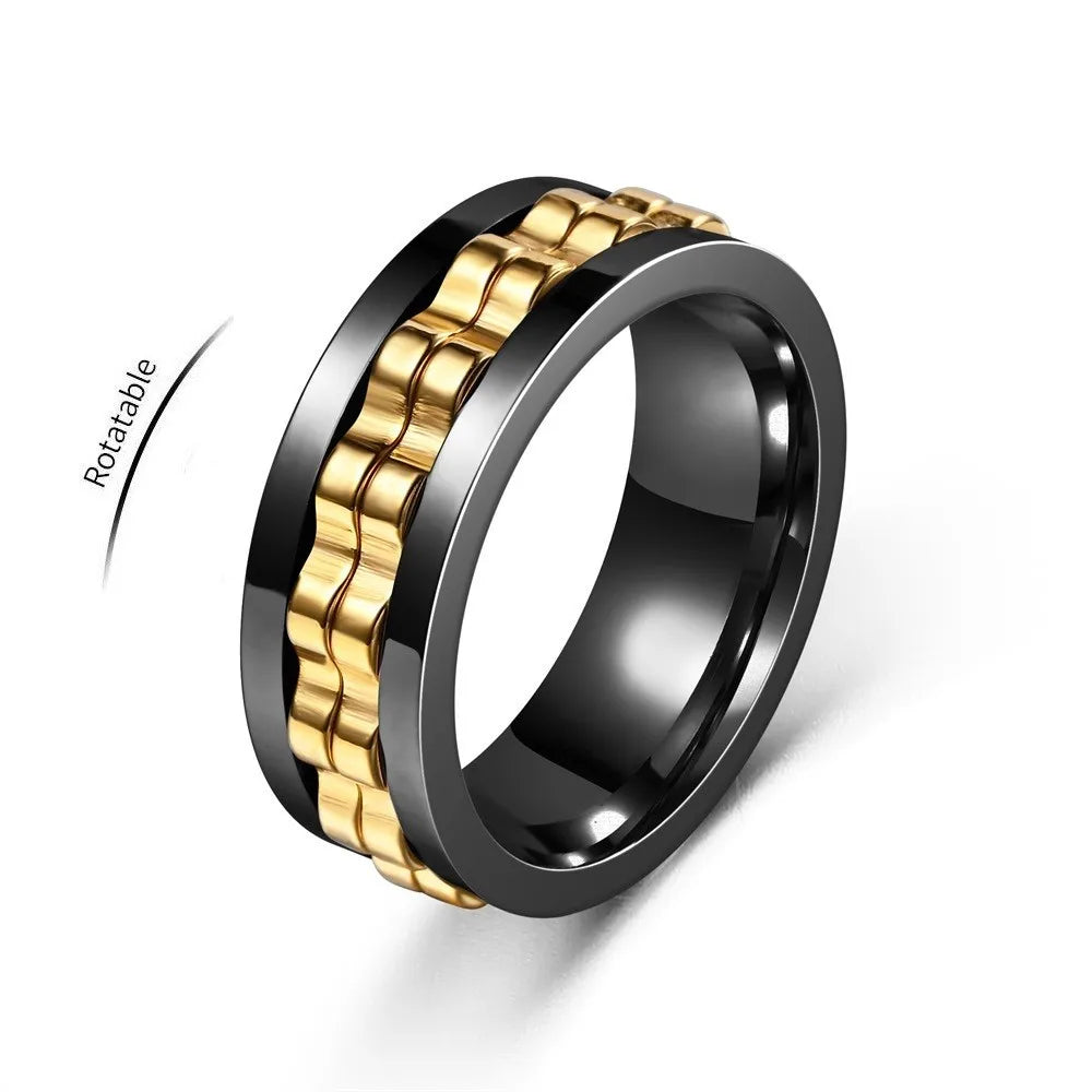 A rotating anxiety ring featuring a gold and black gear chain design.