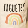 A white fabric featuring the text JUGUETES and a colorful rainbow design.