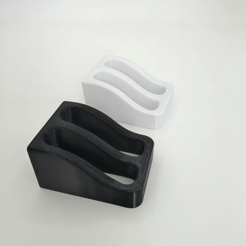 A black double slot wall-mounted wrench organizer rack next to a white version.