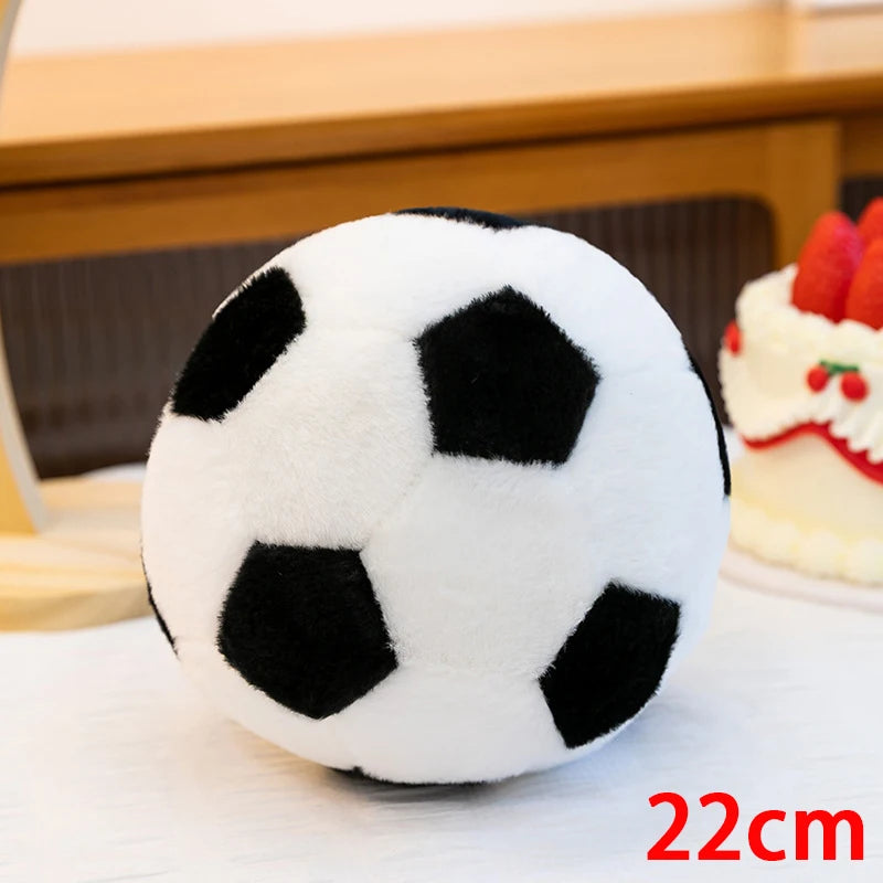 A white and black realistic football plush pillow resting on a white surface.