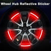 A close-up view of a car wheel hub with a bright red reflective sticker applied to the center cap.