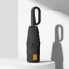 A black compact folding umbrella with a handle is shown against a white background.