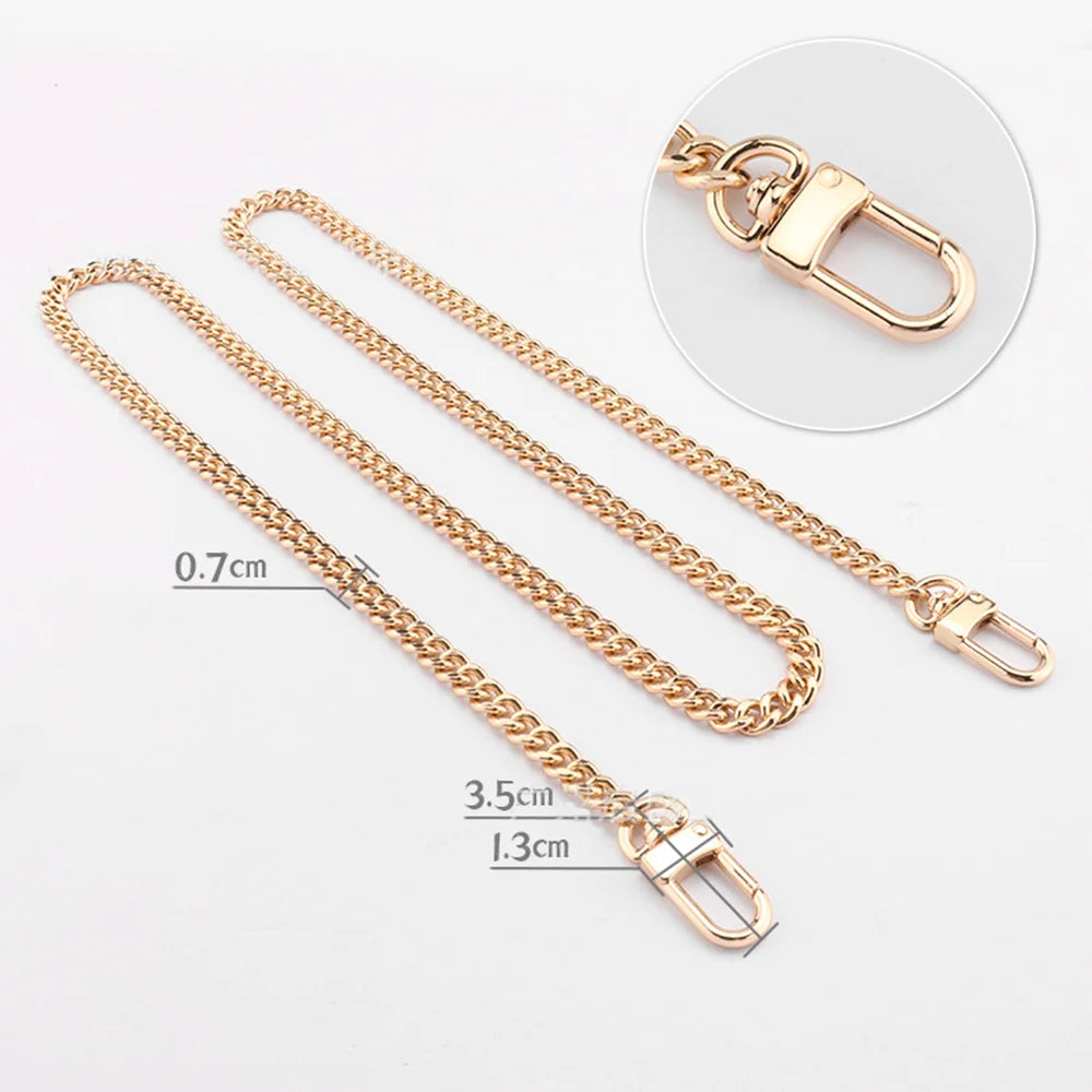 Gold-toned metal purse chain with adjustable buckles and a lobster clasp shown on a white background.