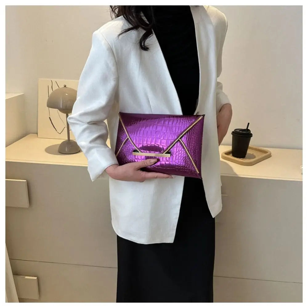 A woman holds a purple crocodile pattern PU envelope clutch with a coin pocket in front of a white blazer.
