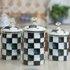 Three white and black checkerboard porcelain storage jars for tea, coffee, and sugar