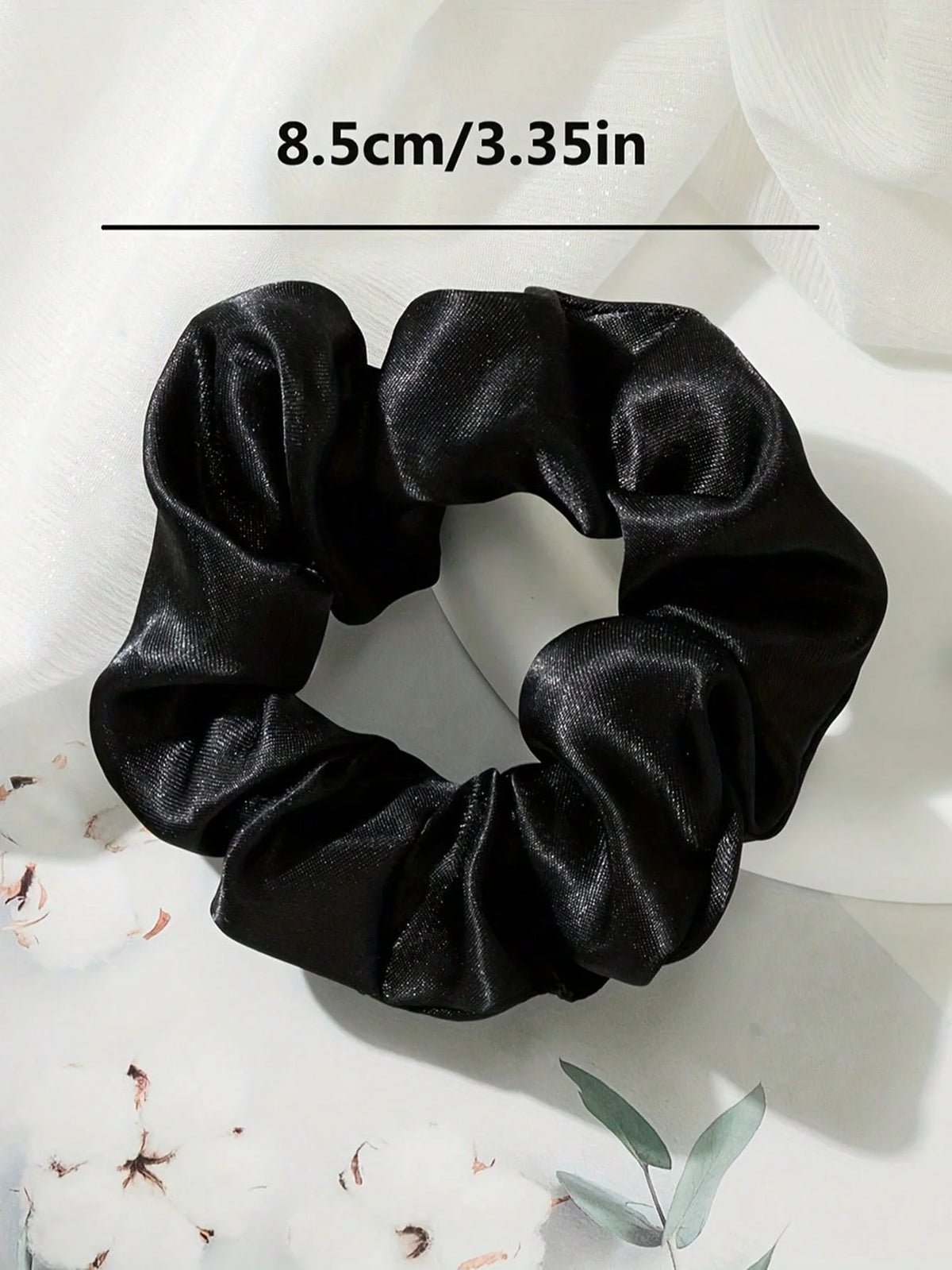 Scrunchies en satin noir, noués en forme de nœud.