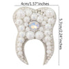 A white pearl and rhinestone flower-shaped brooch or patch with a sparkling center.