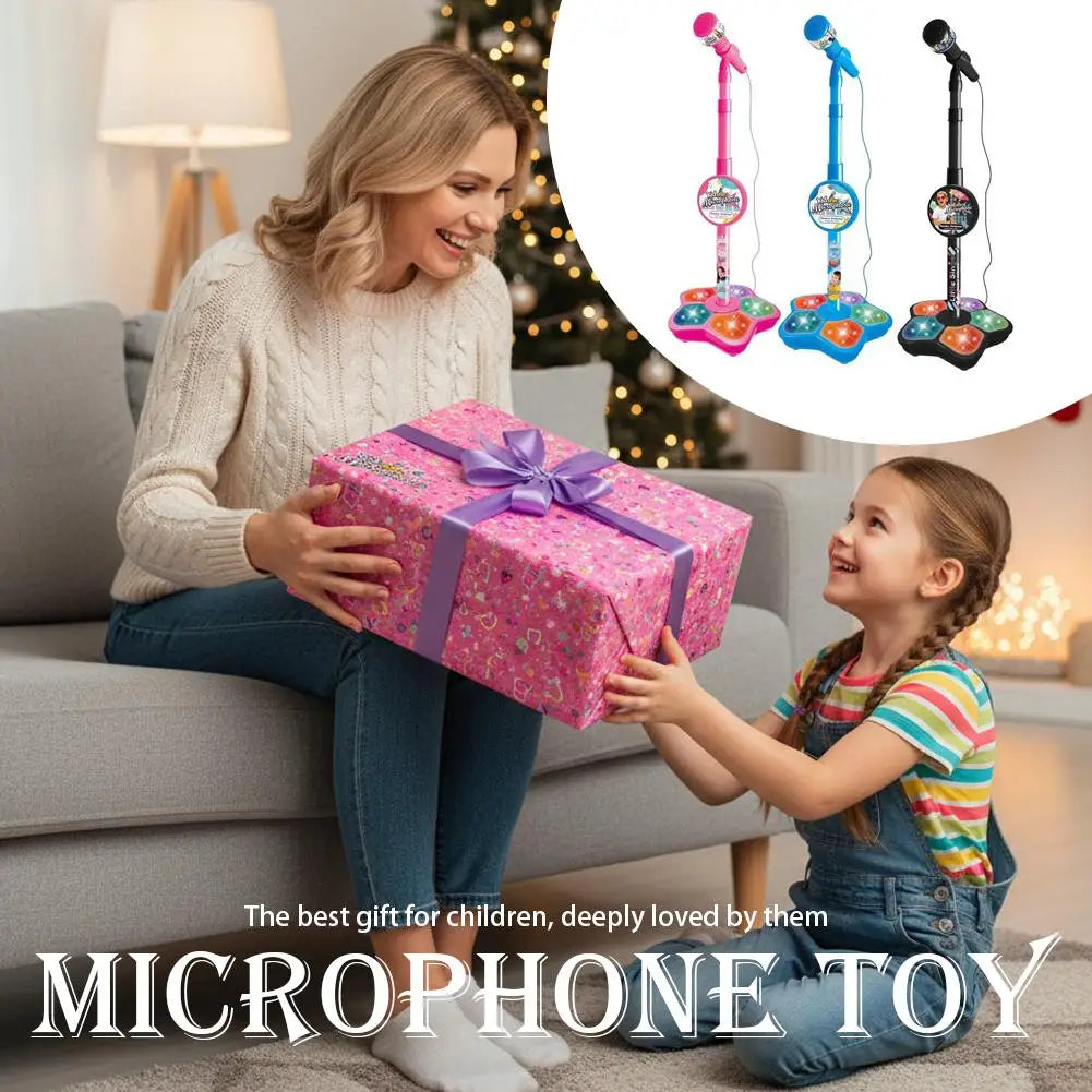 A girl is holding a microphone toy with light effects, sitting on a couch with a gift box nearby.
