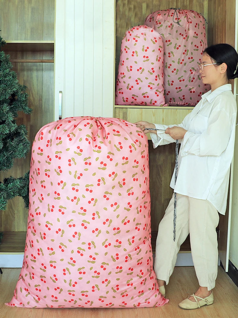 A pink drawstring laundry bag with a floral pattern is displayed next to a woman in a white shirt.