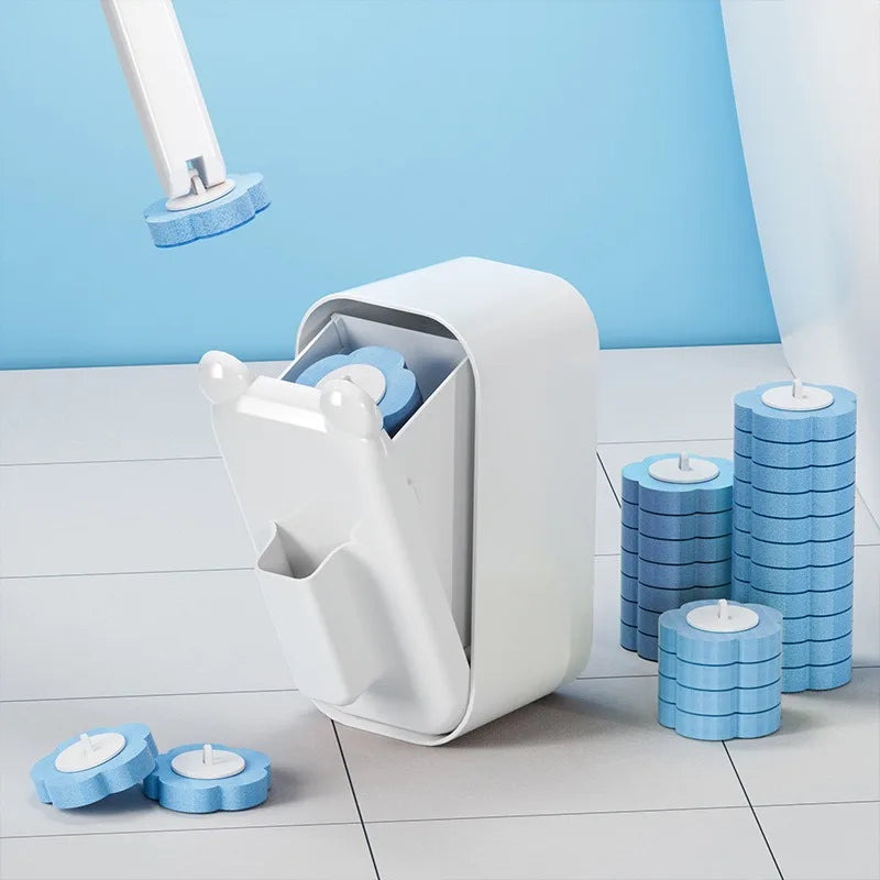 A white wall-mounted disposable toilet brush set with blue heads is shown against a light blue wall and wooden floor.