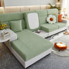 A light green elegant jacquard sofa slipcover with a white backrest and decorative pillows in a modern living room setting.