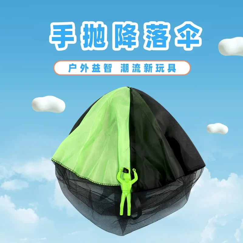 A green and black parachute toy with a small green soldier inside, designed for outdoor kids play.