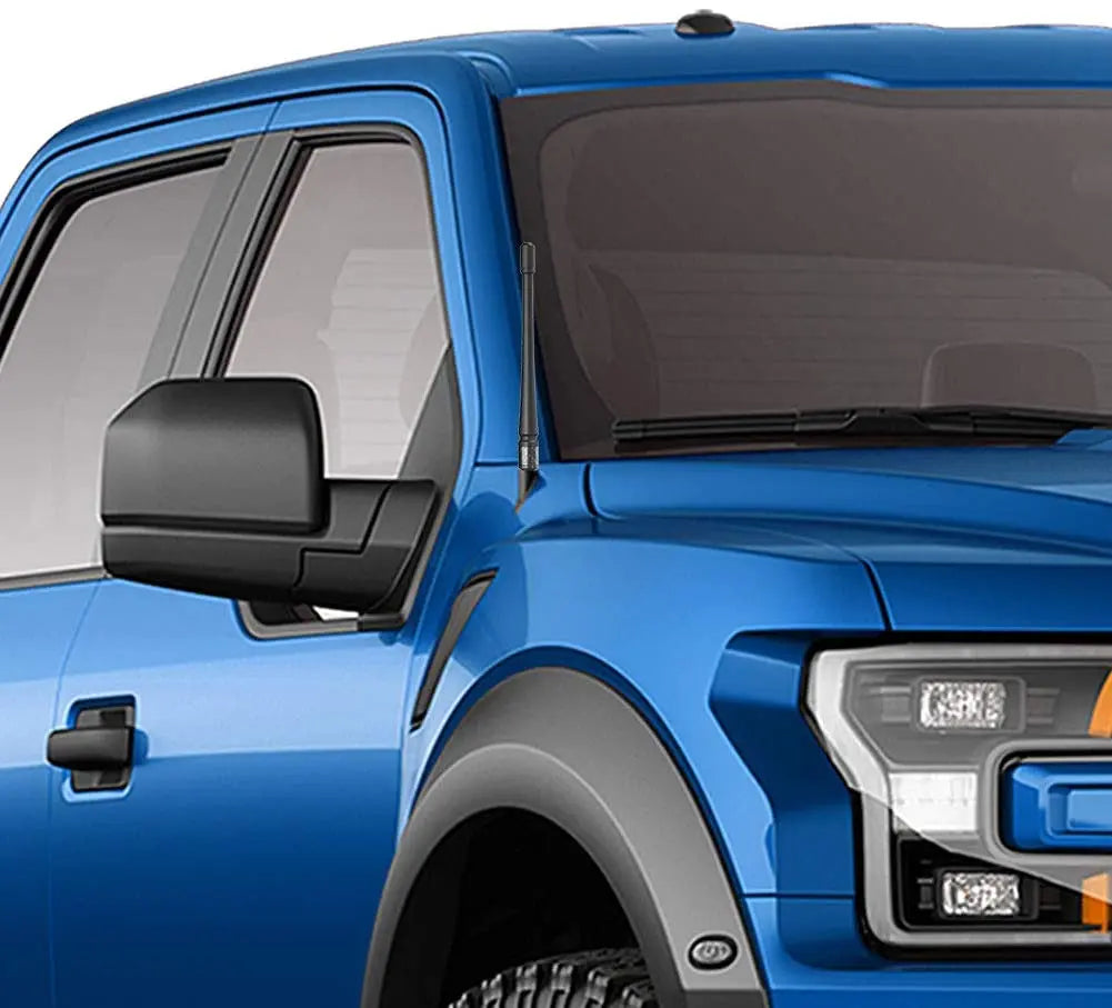 Close-up of a blue truck cab showing an installed universal car radio antenna.