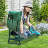 A woman sits on a green foldable garden kneeler seat with a tool pouch in a grassy garden.