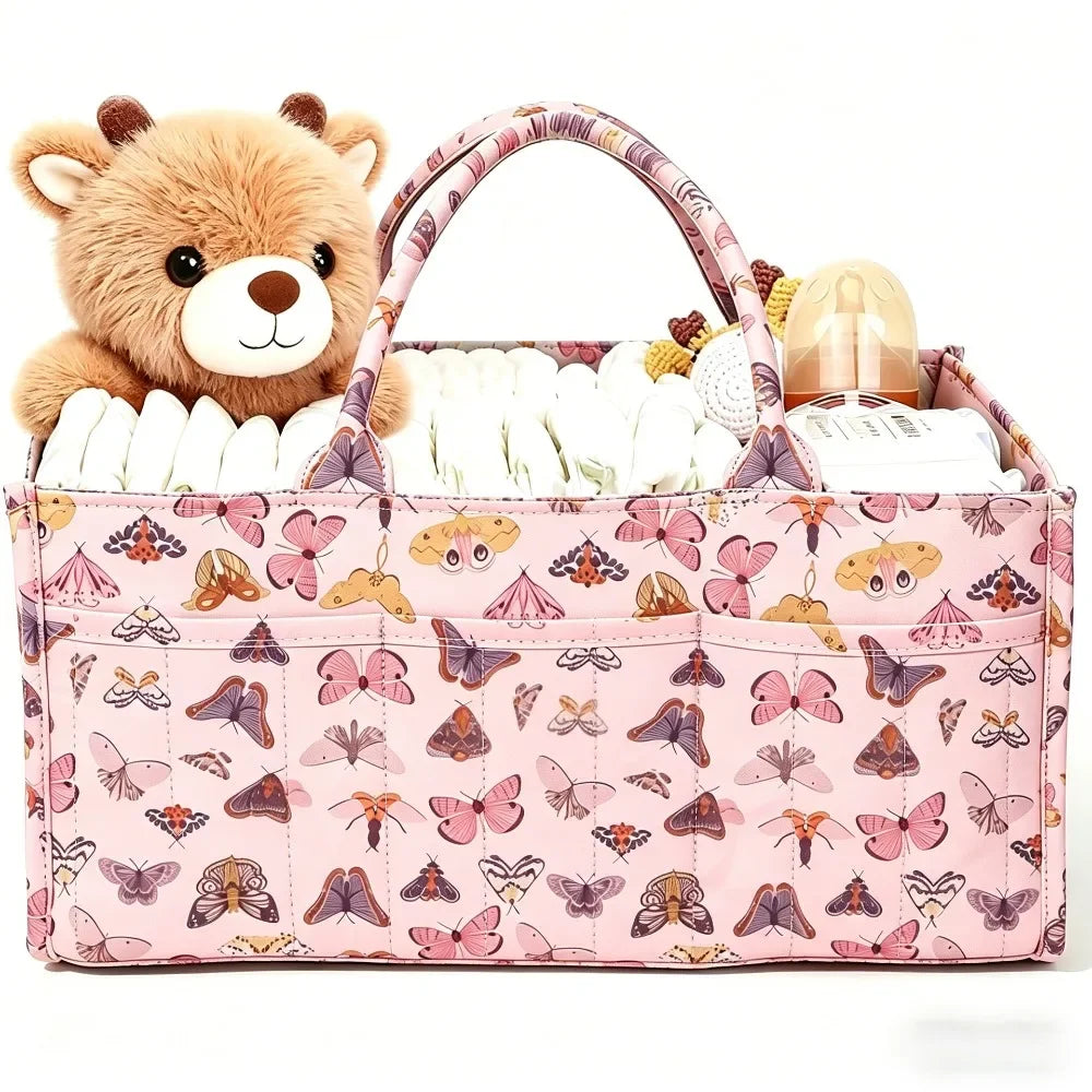 A pink floral diaper organizer bag featuring a teddy bear charm and multiple compartments for baby supplies.