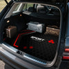 Interior view of a vehicle trunk showing black and red patterned mats and storage boxes.
