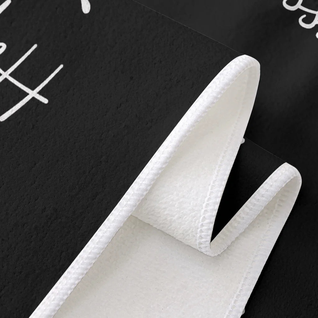 A close-up view of a white kitchen towel folded in an L shape against a dark background.
