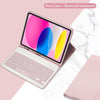 A pink iPad case is shown open with a detachable Bluetooth keyboard resting beside it on a white marble surface.