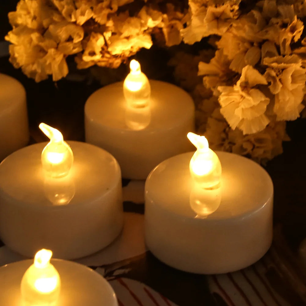 A close-up of several white LED tea lights with flickering flames set against a dark background.