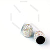 A close-up of crystal-cut tire valve caps with multicolored glitter covering the surface.
