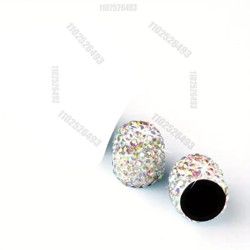 A close-up of crystal-cut tire valve caps with multicolored glitter covering the surface.