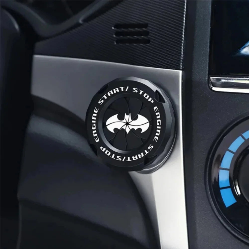 Close-up of a black rotating protective cover for a car ignition start button on a vehicle dashboard.