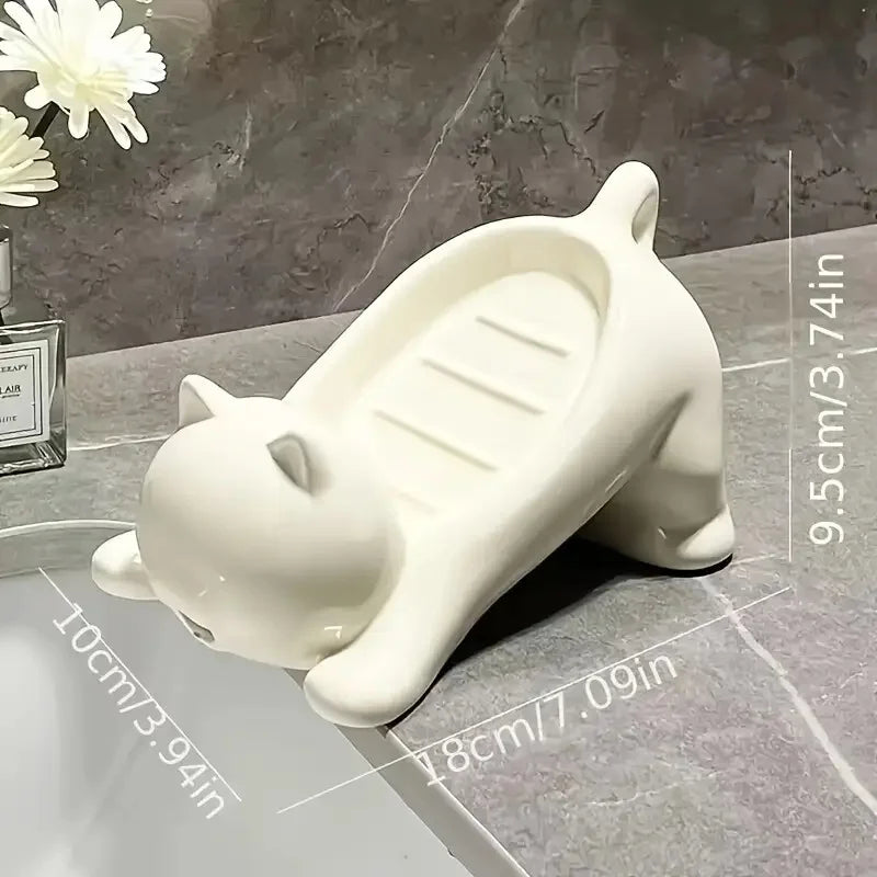 White cat-shaped soap dish with a drainage tray resting on a gray marble surface.