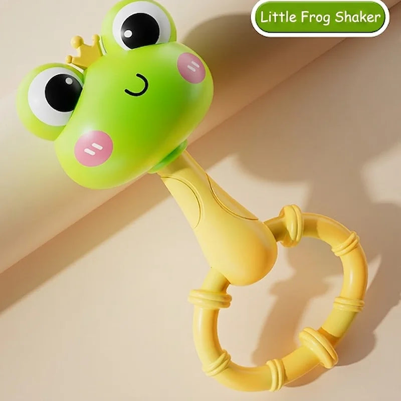 A bright green frog shaker toy with large eyes and a yellow ring is shown against a light background.