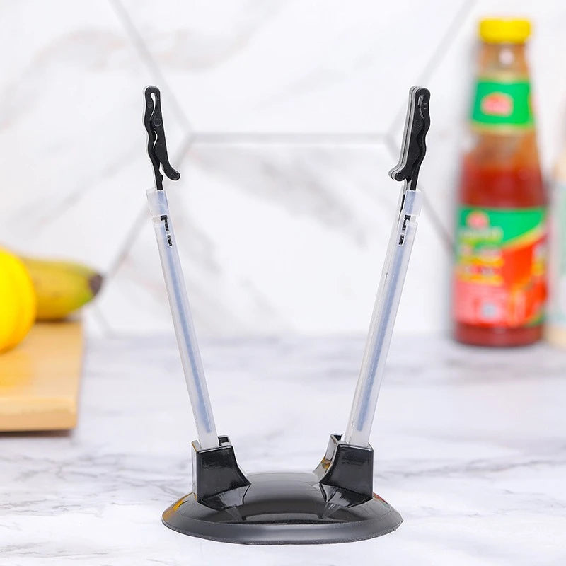 A black adjustable bag holder rack with silver rods is shown on a white marble surface.