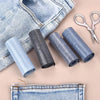 Rolls of denim fabric and a pair of sewing scissors for iron-on patches