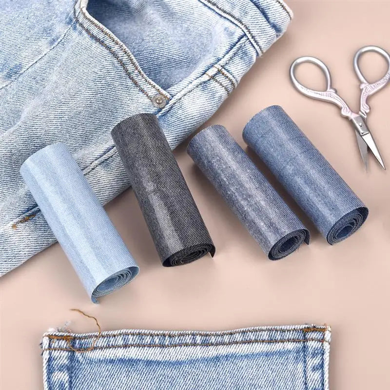 Rolls of denim fabric and a pair of sewing scissors for iron-on patches