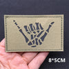 A rectangular olive green tactical patch featuring a black silhouette of a clenched fist.