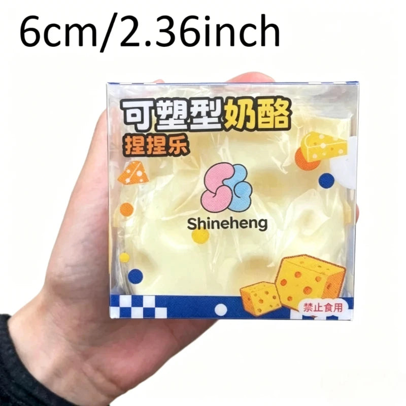 Eine Hand hält einen klaren Plastikbehälter mit gelben Käsestückchen, beschriftet für Fidget-Spielzeug.