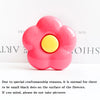 A bright pink, flower-shaped silicone phone grip stand with small black dots on the surface.