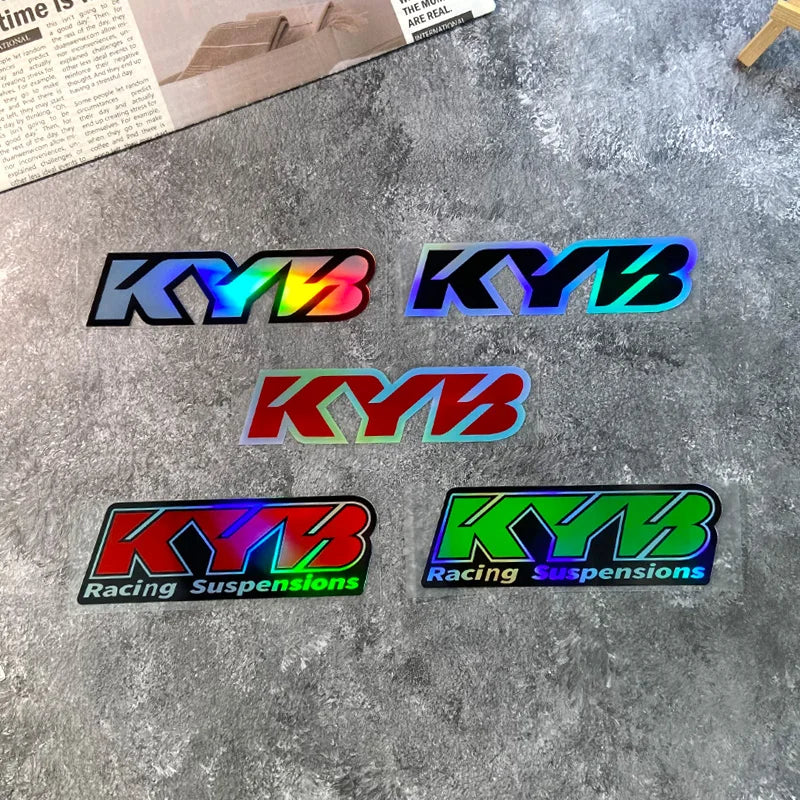 Set of four colorful KYB racing suspension fork stickers on a gray surface.