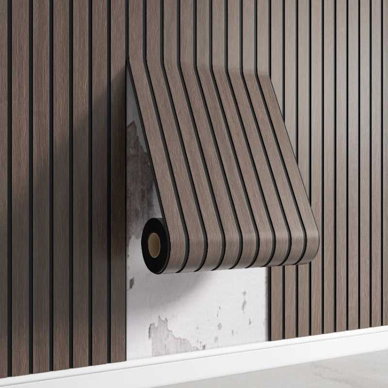 A close-up of a brown wood-grain self-adhesive wall panel installed on a vertical wooden slat wall.