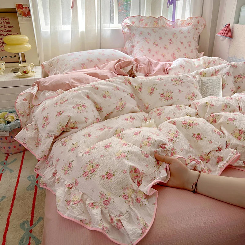A pink floral duvet cover set with matching pillowcases and a flat sheet is displayed on a bed.