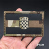 A rectangular tactical patch featuring a camouflage pattern and a national flag design with hook-and-loop backing.
