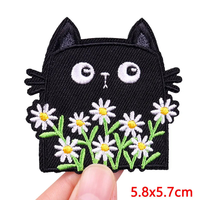 Black cat embroidered iron-on patch with white floral accents