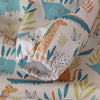A close-up of a long-sleeve waterproof baby bib with an orange giraffe design on a white fabric background.