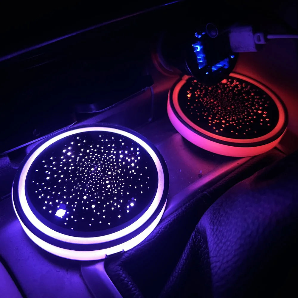 Close-up of a car interior showing rechargeable LED cup holder lights illuminating the dashboard.