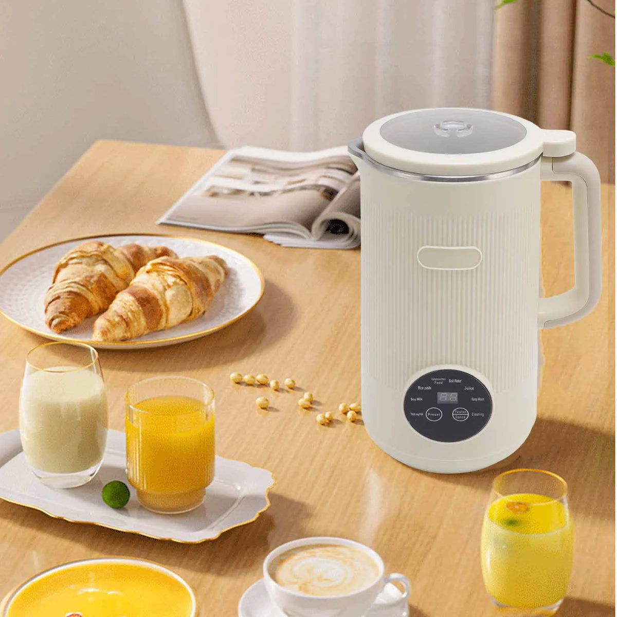 A white automatic nut milk maker is shown on a wooden table with fresh fruit and juice glasses.