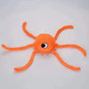 An orange plush toy shaped like a starfish with eight arms and a central eye.