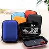 A collection of black, blue, orange, and red hard EVA protective cases for a SanDisk Extreme Portable SSD.