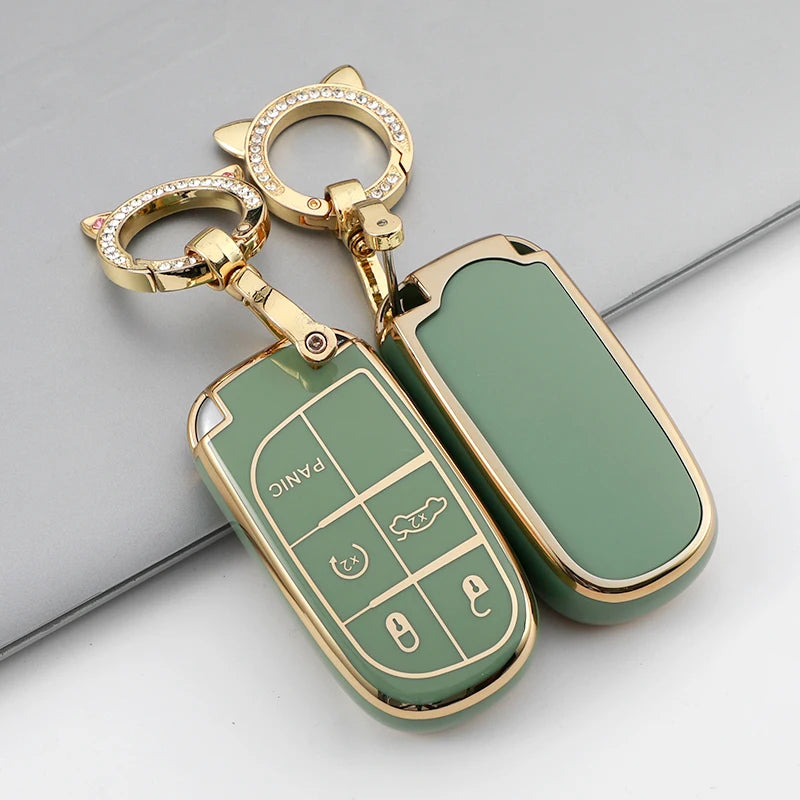 A gold-toned key fob with a green TPU case cover and a keyring is shown on a gray surface.
